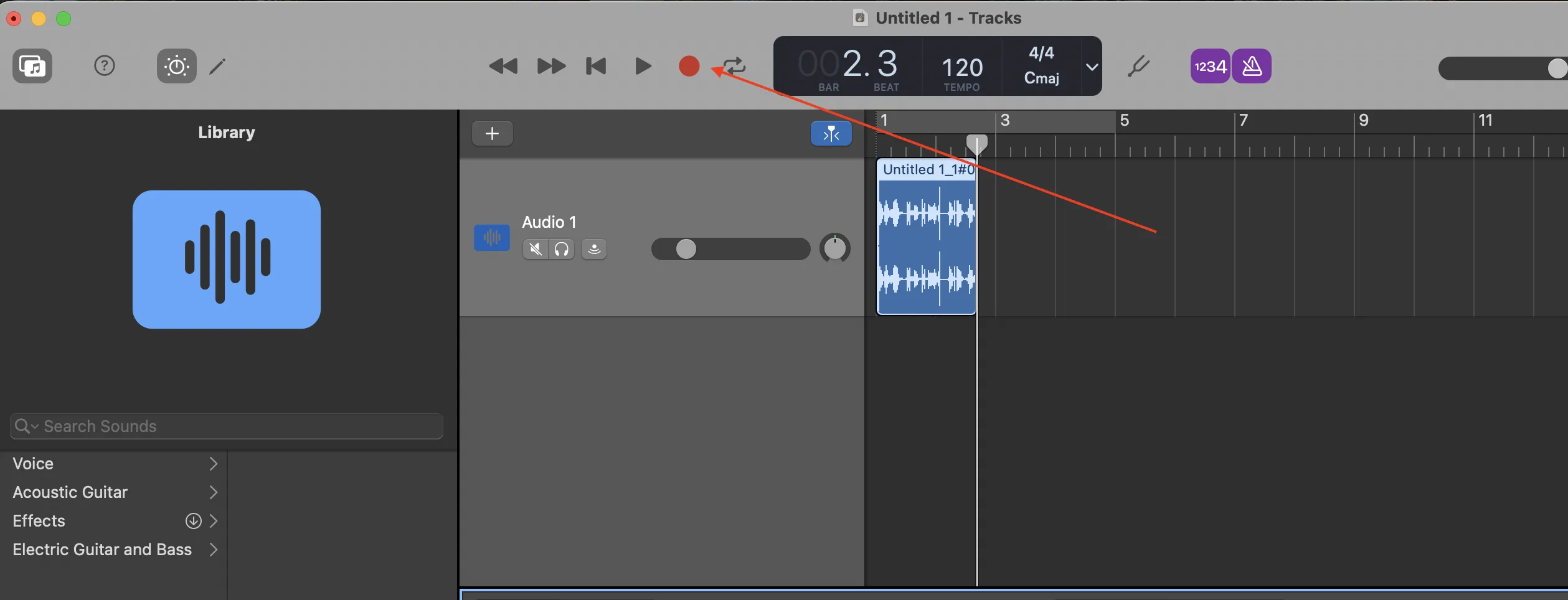 GarageBand main window showing an Audio track named 'Audio 1' with a recorded stereo waveform region, and the transport record button highlighted with a red arrow